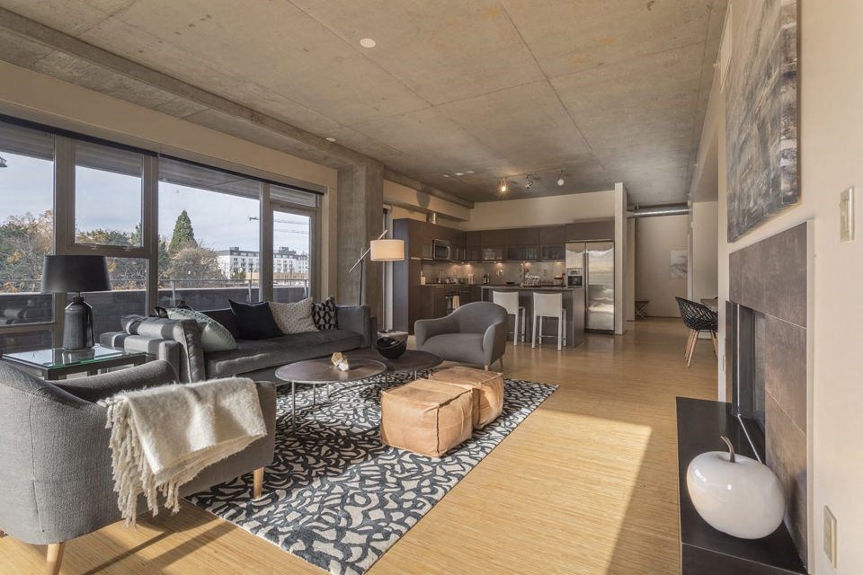 a living room with a couch and a table  and a kitchen