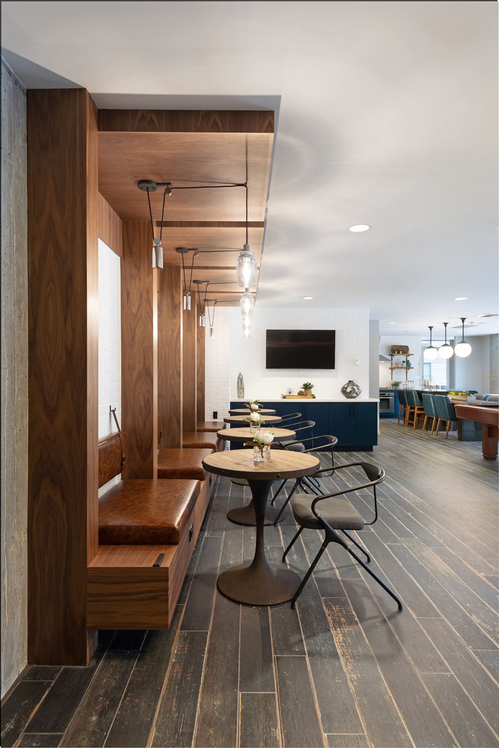 a dining room with tables and chairs and a wall with a television