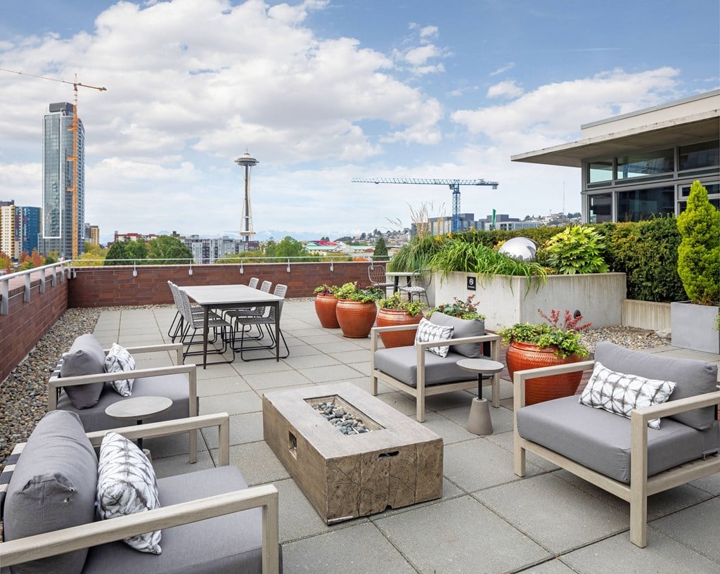 a roof terrace with patio furniture and a view of the city