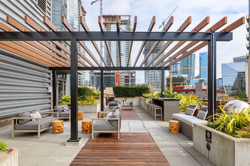 a roof terrace with furniture and a view of the city