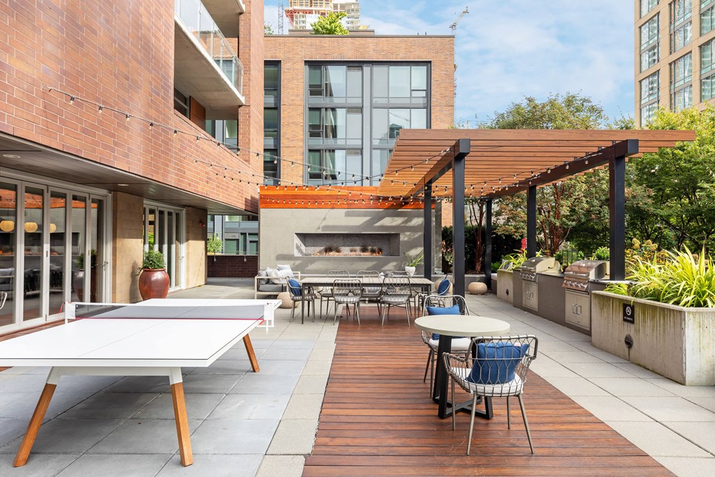 a patio with tables and chairs and a fire pit