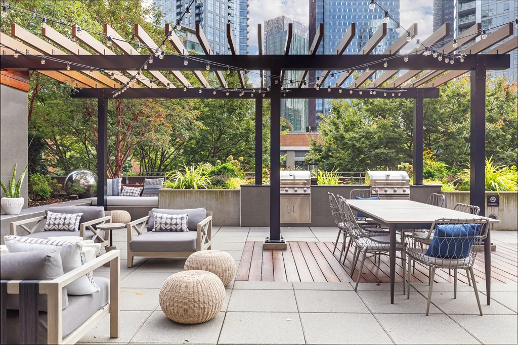 a rooftop patio with tables and chairs and a pergola