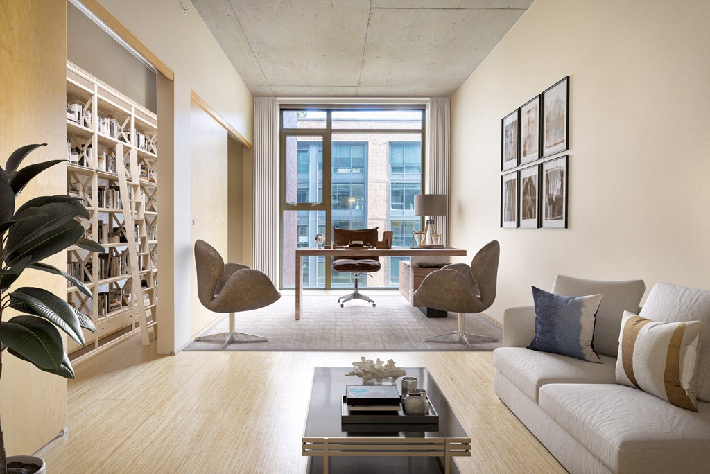 a living room with a couch and a desk and a window