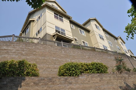 A building with a balcony and a wall with plants on it.