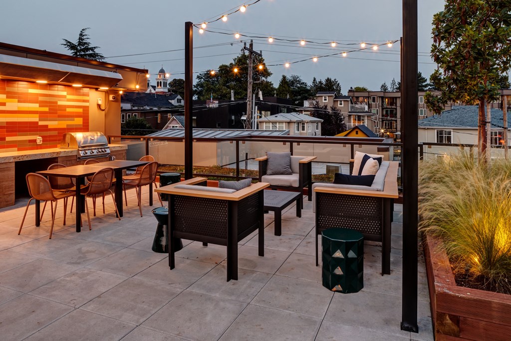 a rooftop patio with tables and chairs and lights