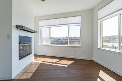 A room with a fireplace and a view of the city.