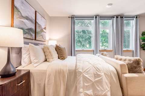 A bedroom with a large bed and a painting on the wall.