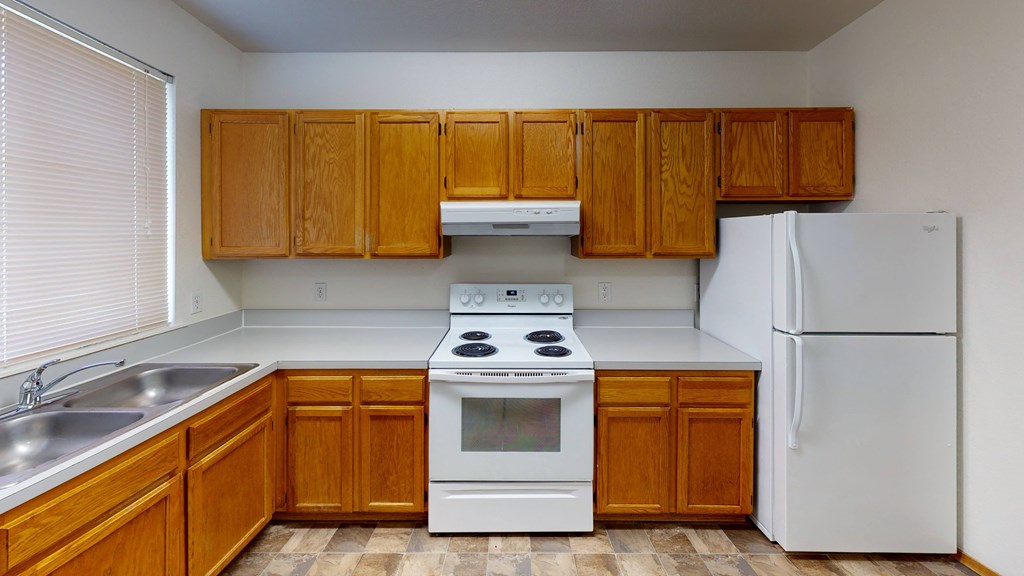 a kitchen with white appliances and wooden cabinets