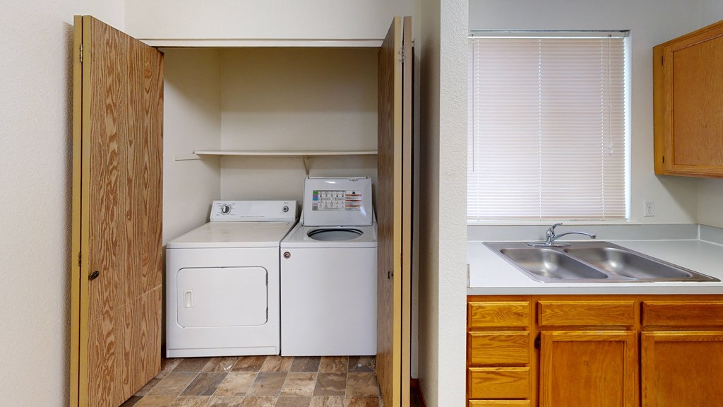 a kitchen with a washer and dryer and a sink and a laundry room