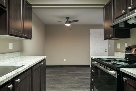 a kitchen with a stove and a ceiling fan