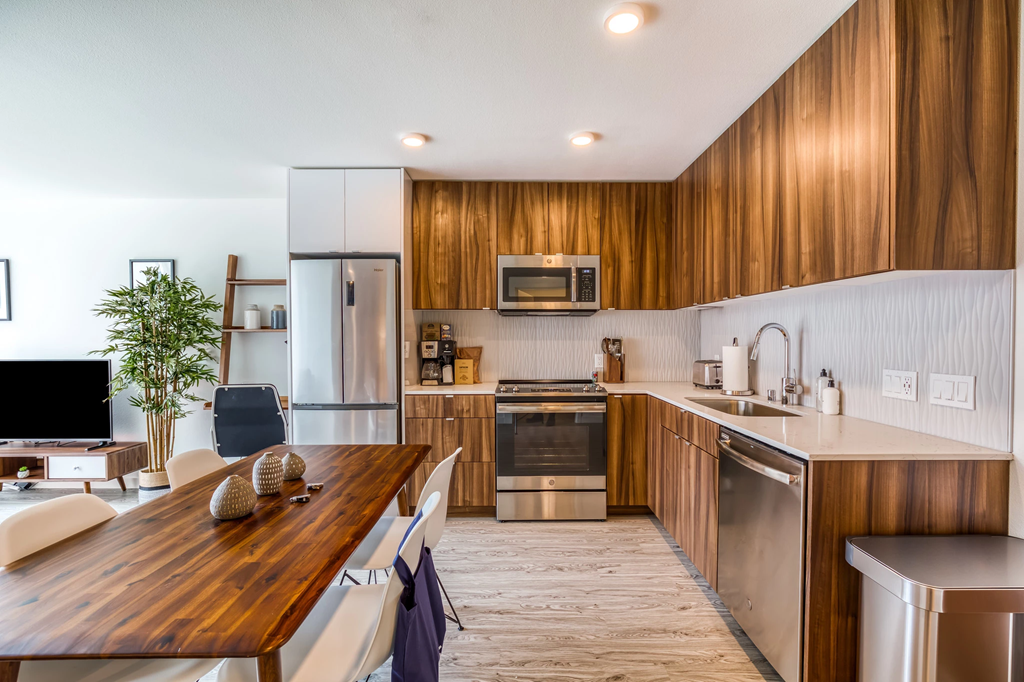 a kitchen with wooden cabinets and stainless steel appliances and a wooden table