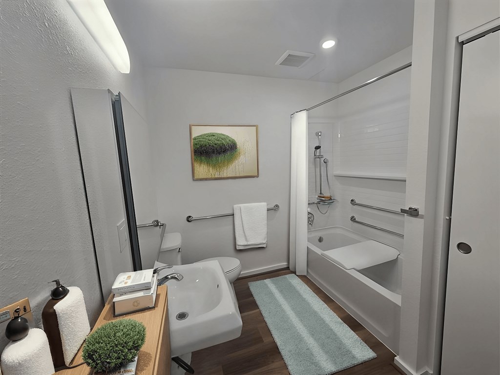 A bathroom with a white tub and a white towel hanging on the wall.