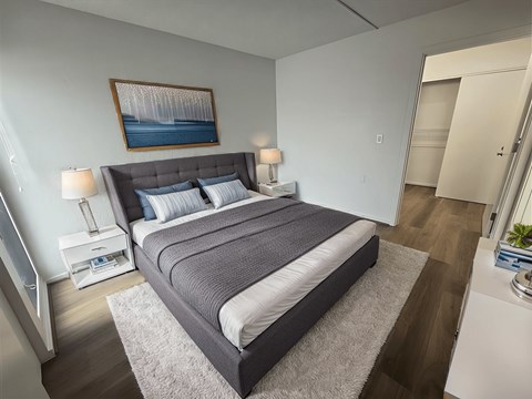 A bedroom with a large bed and a painting on the wall.