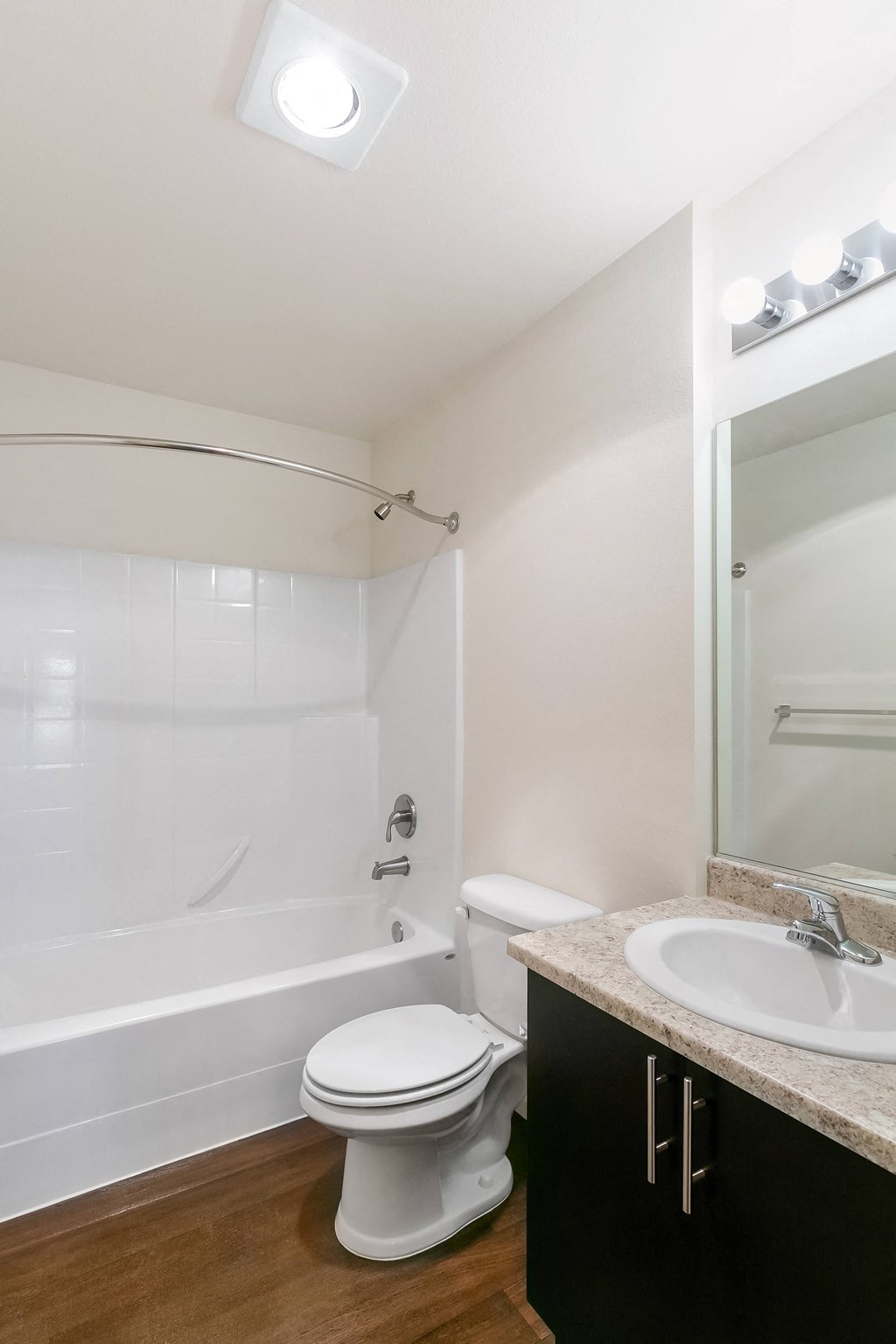 a bathroom with a toilet sink and tub and a mirror