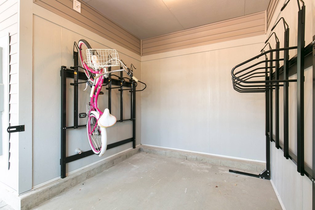 a pink bike hanging on a rack in a garage