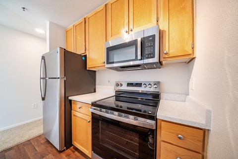 A kitchen with wooden cabinets and a stainless steel refrigerator.