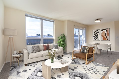 A living room with a couch, a chair, a table, and a potted plant.