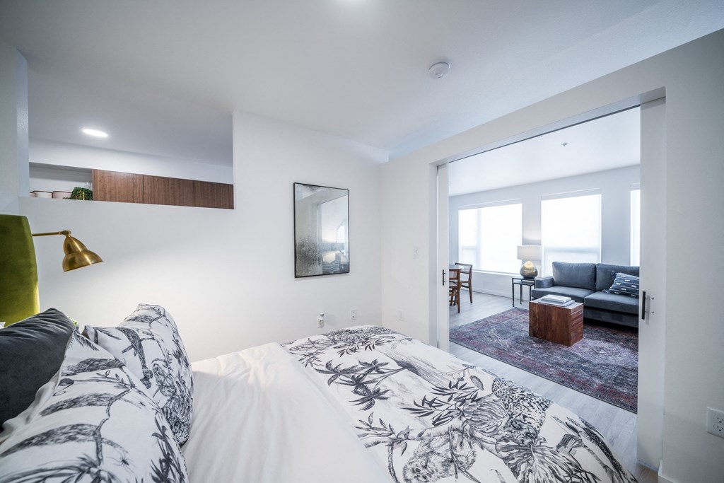 a bedroom with a bed and a living room with a couch
