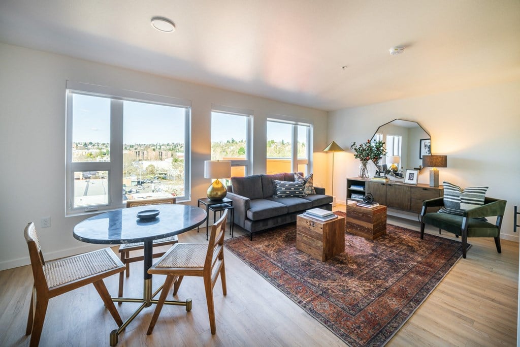 a living room with a round table and a couch and a dining table