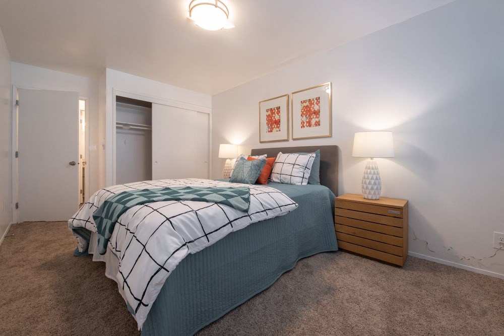 a bedroom with a bed and two lamps and a closet