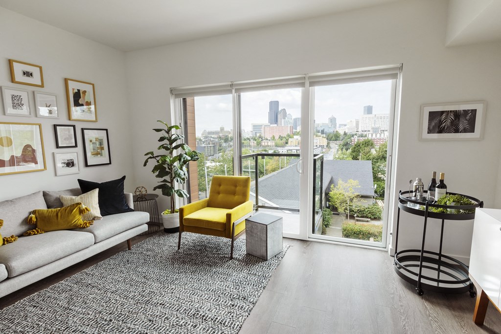 a living room with a couch and a yellow chair and a window