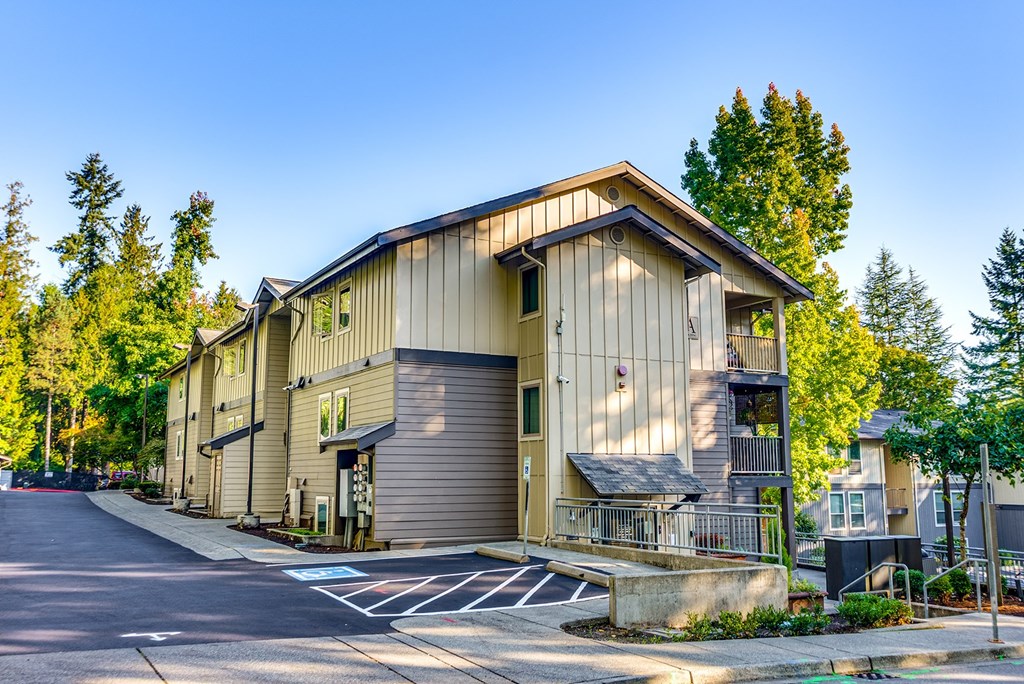 A modern building with a parking lot in front.