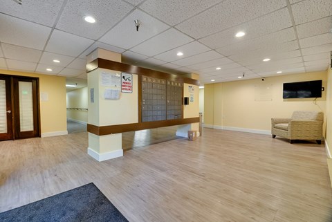 A spacious room with wooden flooring and a television mounted on the wall.