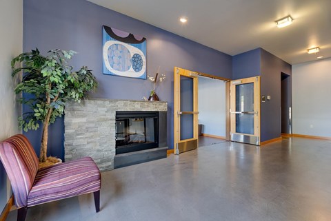 A living room with a fireplace and a painting on the wall.