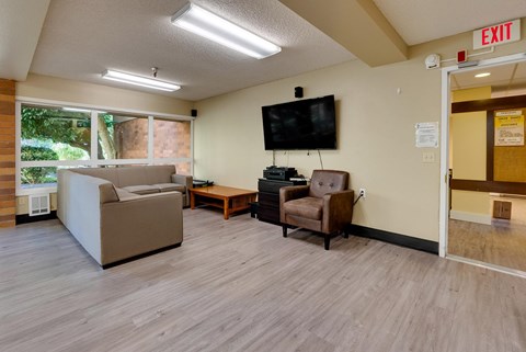 A living room with a couch, chair, and television.
