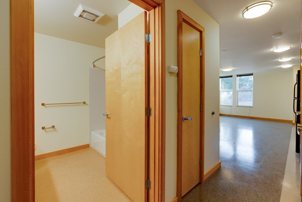 A hallway with two doors and a window.