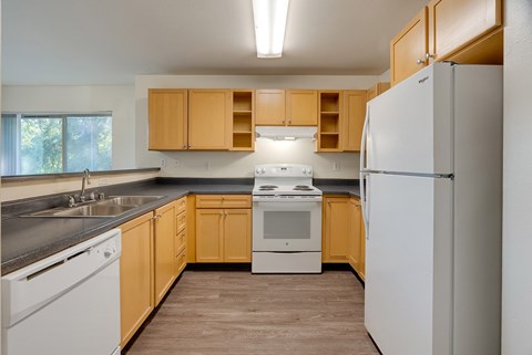 A kitchen with wooden cabinets and white appliances.