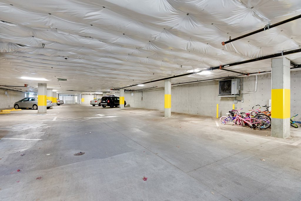 A spacious parking garage with a white ceiling and yellow poles.