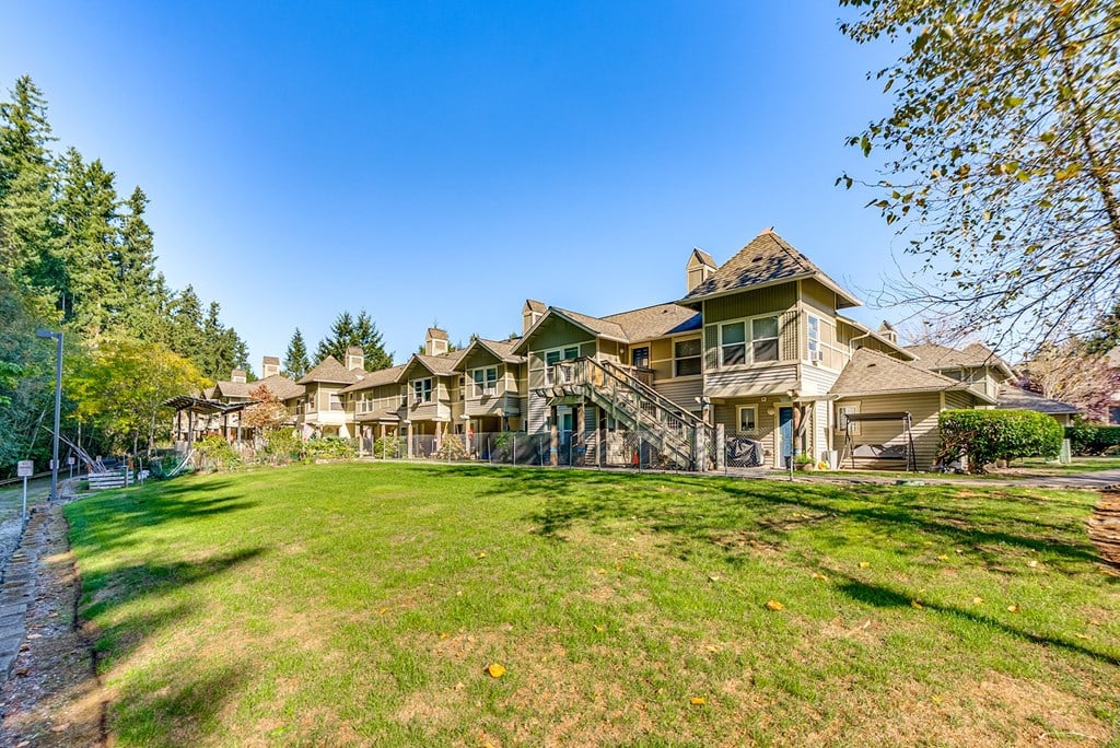 A row of houses with a green lawn in front.