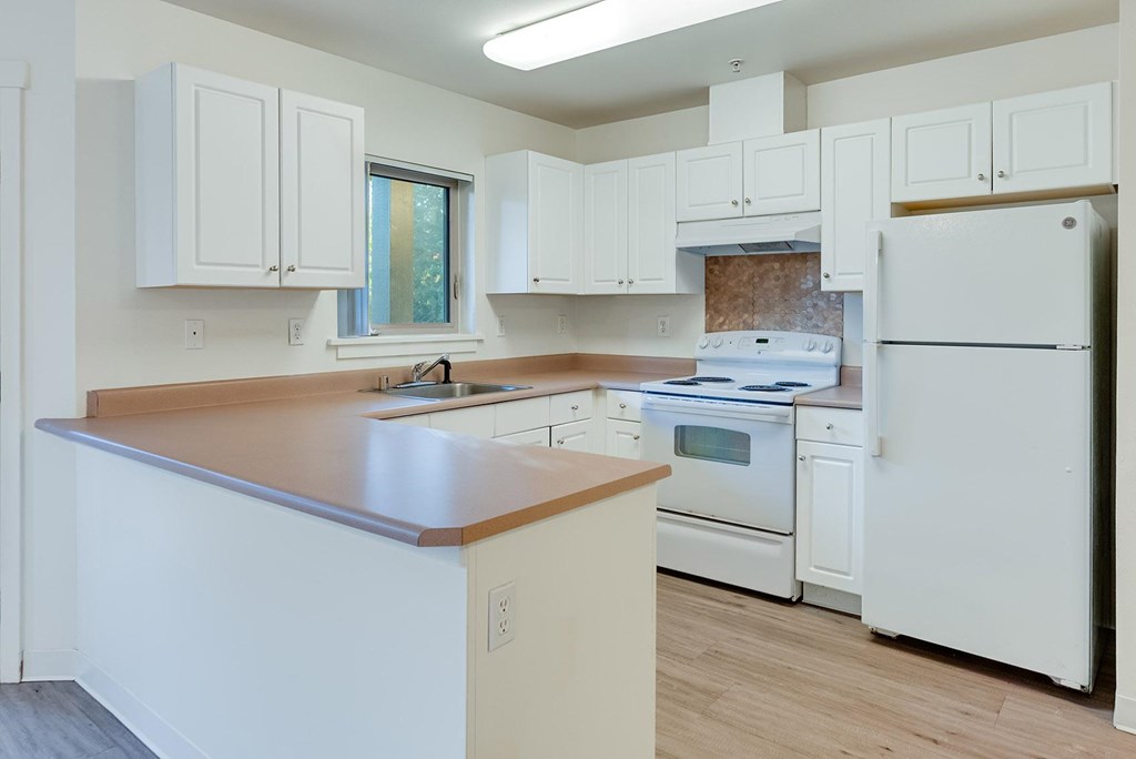 A kitchen with white appliances and wooden countertops.