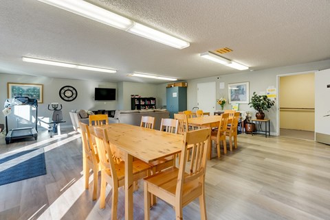 A dining room with a long wooden table and chairs.