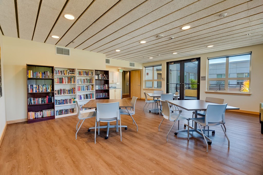 A room with a bookshelf and tables.