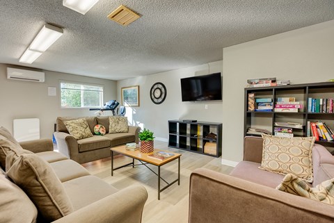 A living room with a brown couch, a coffee table, and a bookshelf.