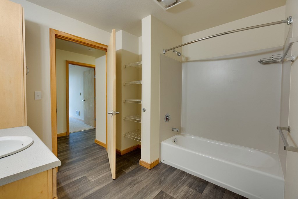 A white bathtub with a shower head in a bathroom.