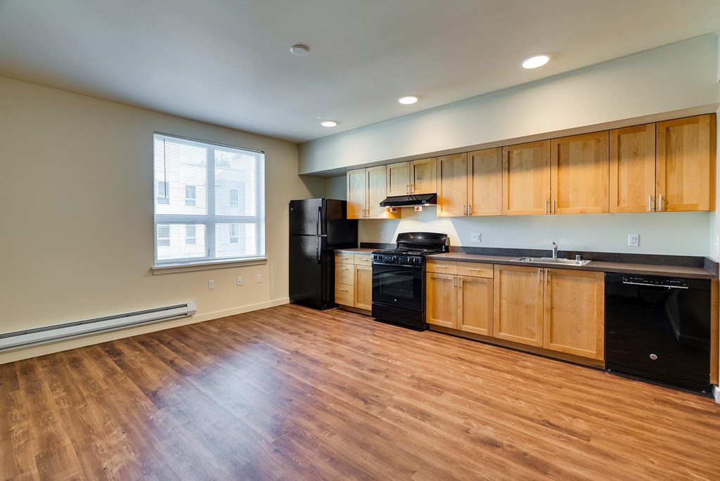 A kitchen with wooden cabinets and black appliances.