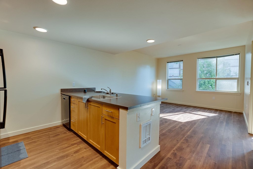 A kitchen with wooden cabinets and a black countertop.