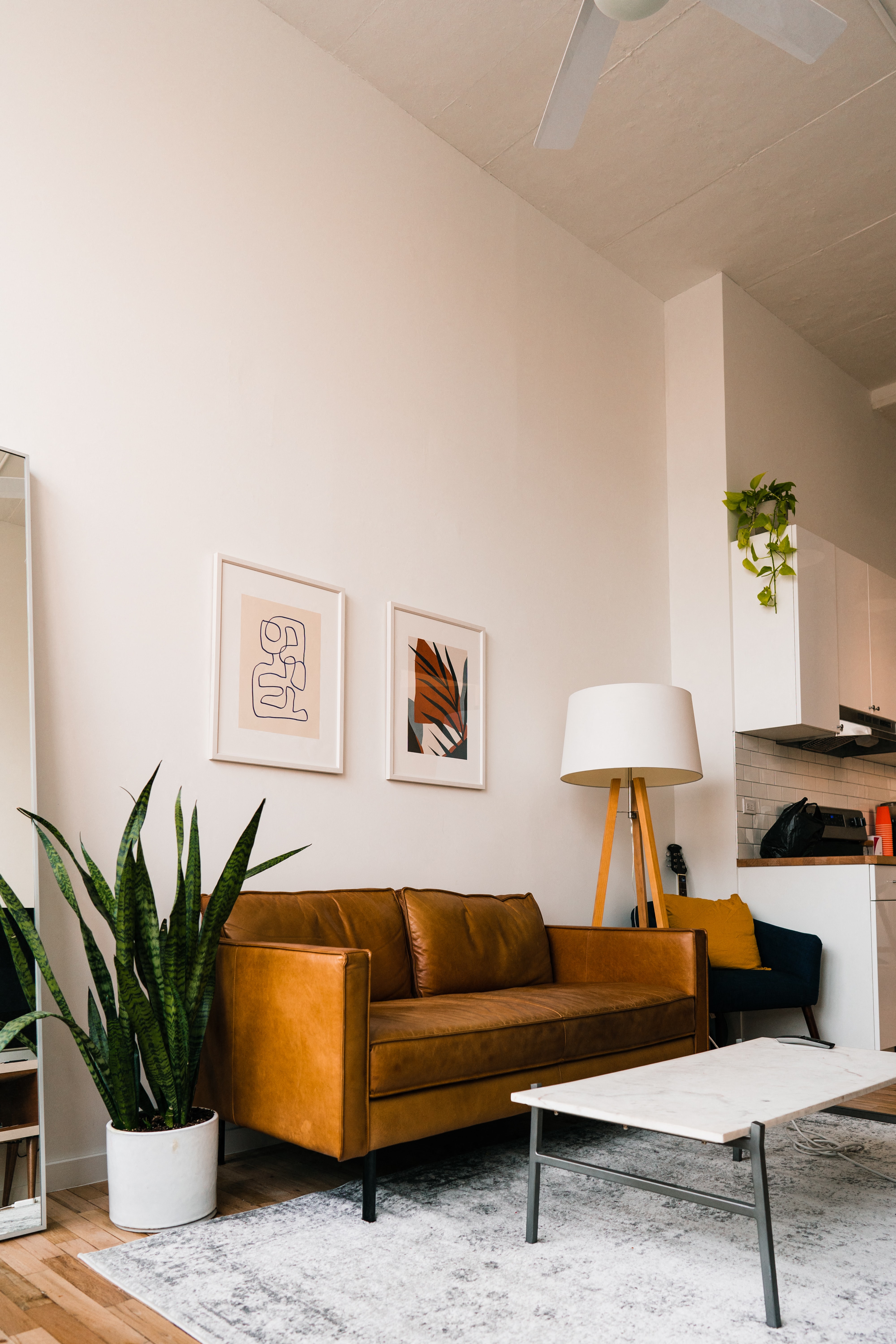 a living room with a brown couch and a white coffee table