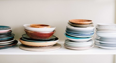 a stack of plates and bowls on a shelf