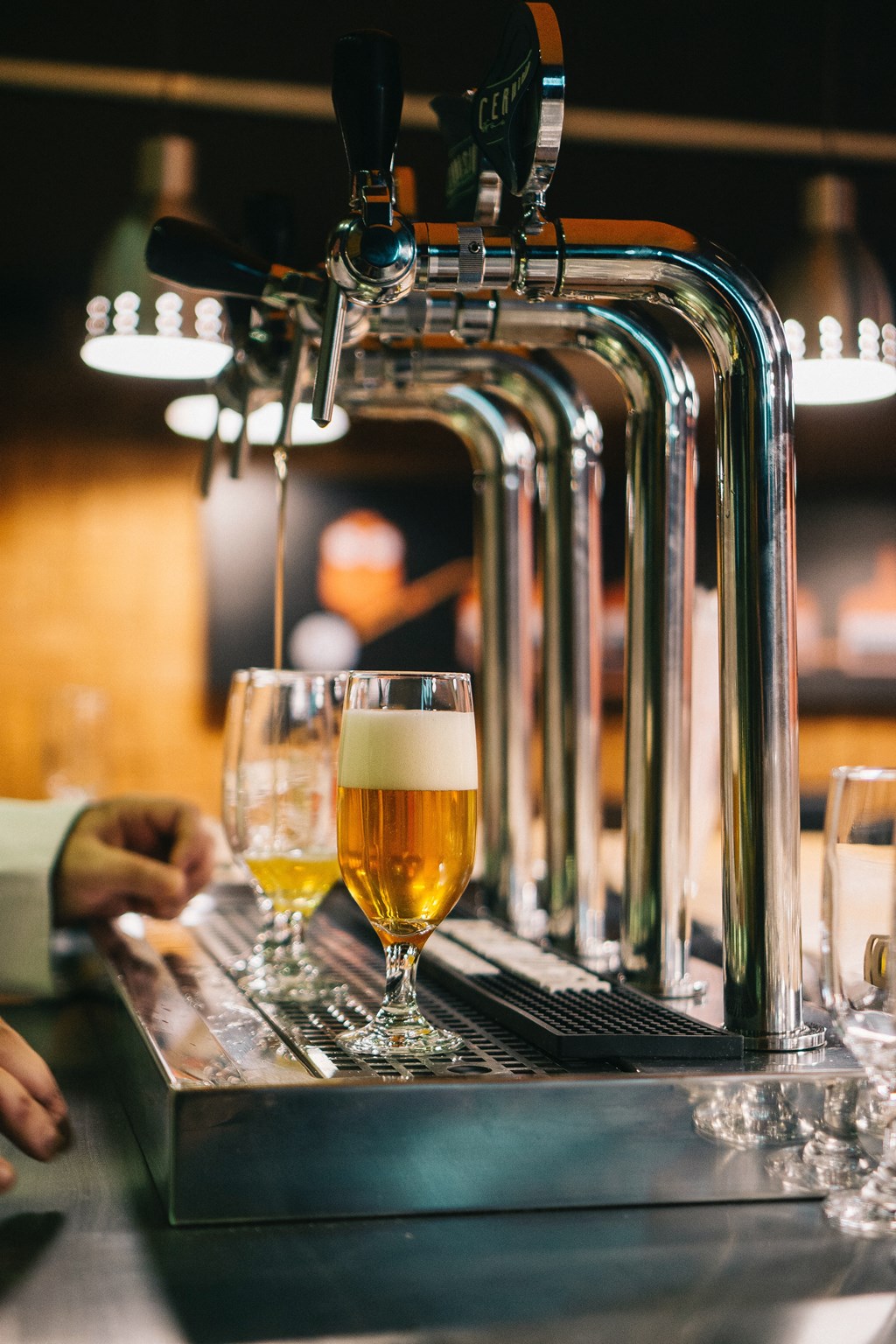 a beer being poured into a glass at a bar
