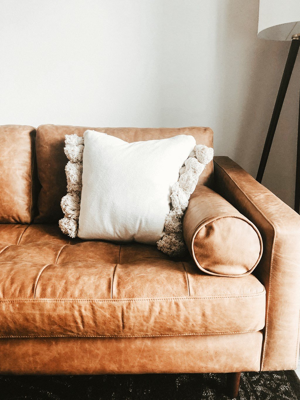 a brown leather couch with a white pillow on it