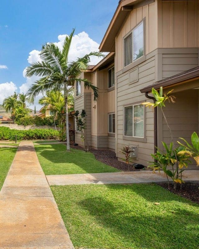 a sidewalk in front of a house with palm trees