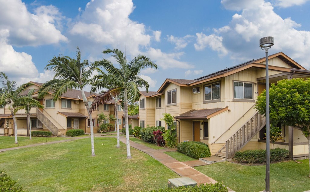 a row of houses with palm trees and a sidewalk