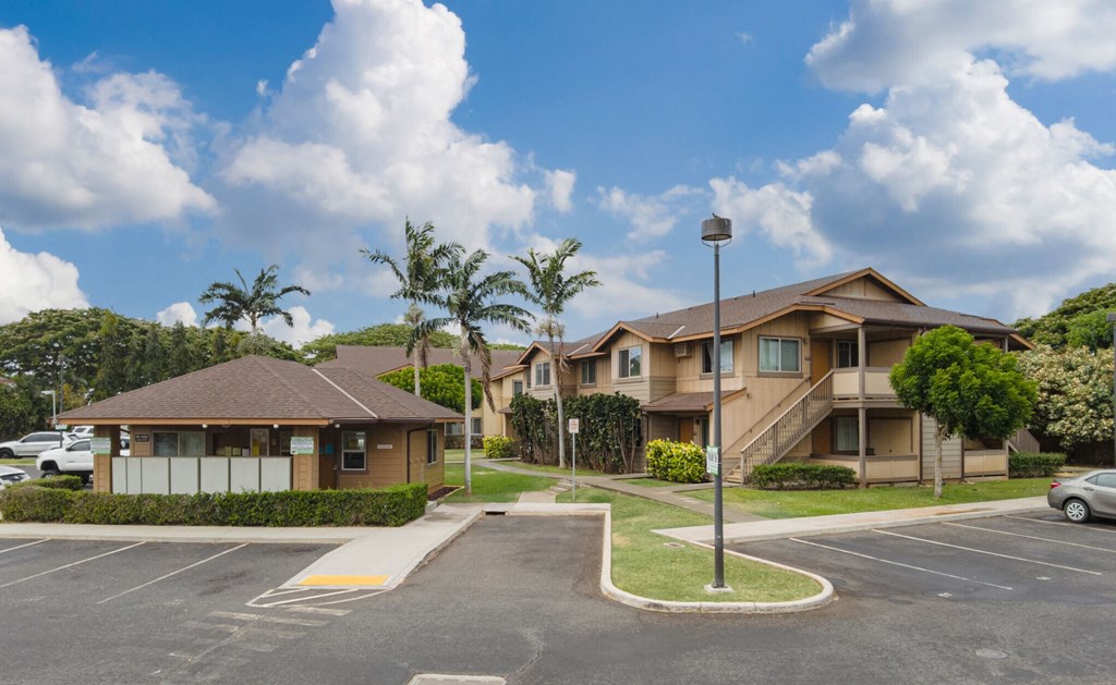 a row of houses with cars parked in a parking lot