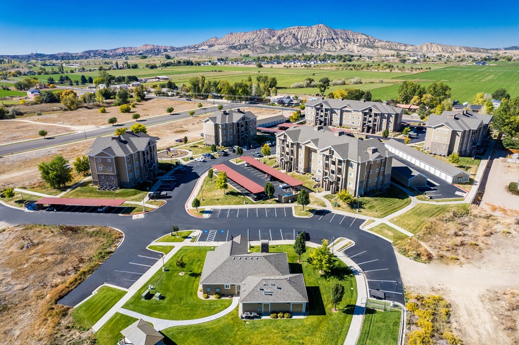 A large, modern building complex with a parking lot in front.