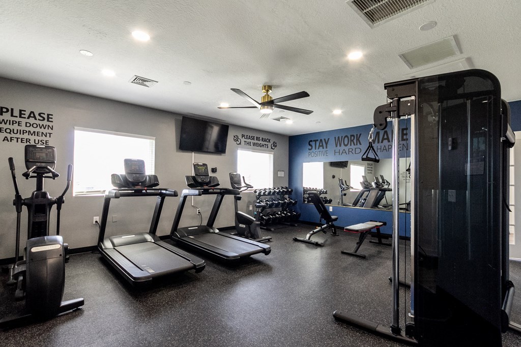 A gym with treadmills, elliptical machines, and a weight machine.