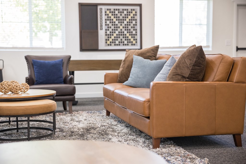 A living room with a brown couch and a blue pillow.